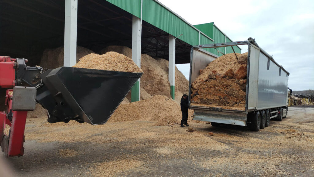 Bulk woodchip biomass being loaded into a transport trailer at an industrial facility, highlighting Halker’s renewable energy engineering expertise in biomass handling, waste-to-fuel conversion, and sustainable jet fuel production processes.