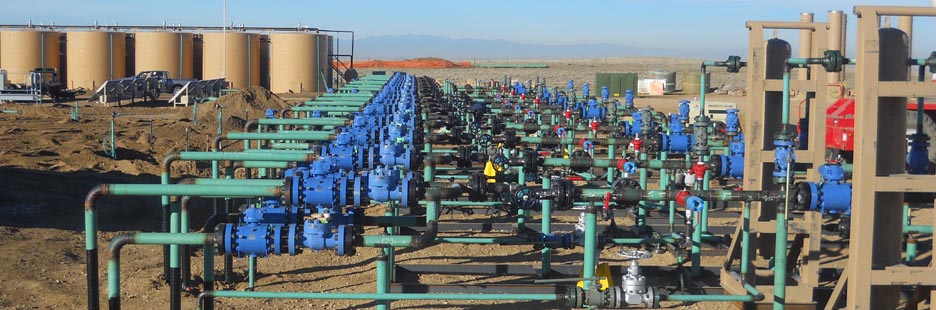 Multi-well pad facility with rows of wellhead assemblies, flowlines, valves, and manifolds arranged on elevated steel supports, showcasing Halker’s engineering expertise in designing high-density upstream production sites optimized for reliability, flow management, and efficient field development.