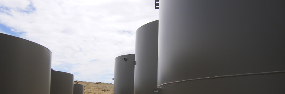 Large industrial water injection tanks arranged on a graded site under an overcast sky, showcasing Halker’s engineering capabilities in designing and supporting high-capacity water management and injection infrastructure for oil and gas operations.