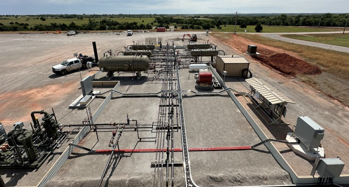 A Permian Basin oil and gas production site with interconnected piping, storage vessels, and equipment laid out across a gravel pad, illustrating Halker’s expertise in OOOOb regulatory compliance walkdowns, emissions assessment, and facility readiness verification.