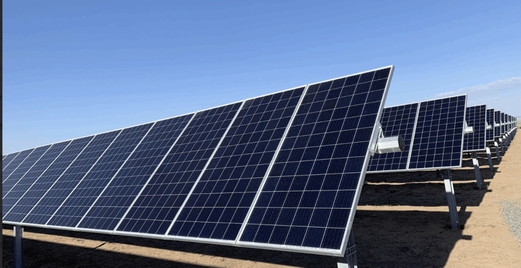 Large ground-mounted solar photovoltaic panels angled toward the sun on a utility-scale solar site, showcasing Halker’s renewable energy engineering expertise in high-voltage solar interconnect design, grid integration, and resilient power infrastructure.