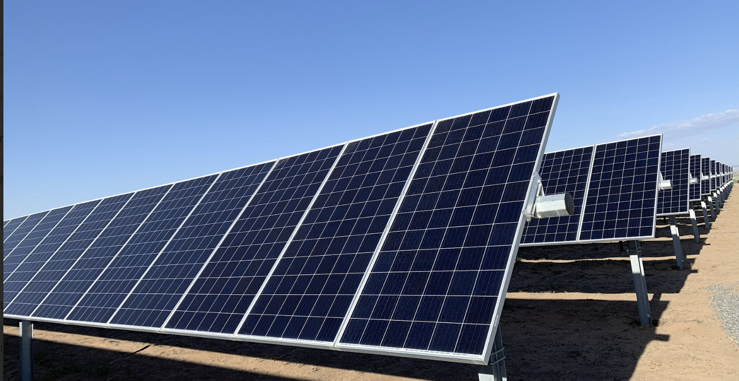 Large ground-mounted solar photovoltaic panels angled toward the sun on a utility-scale solar site, showcasing Halker’s renewable energy engineering expertise in high-voltage solar interconnect design, grid integration, and resilient power infrastructure.